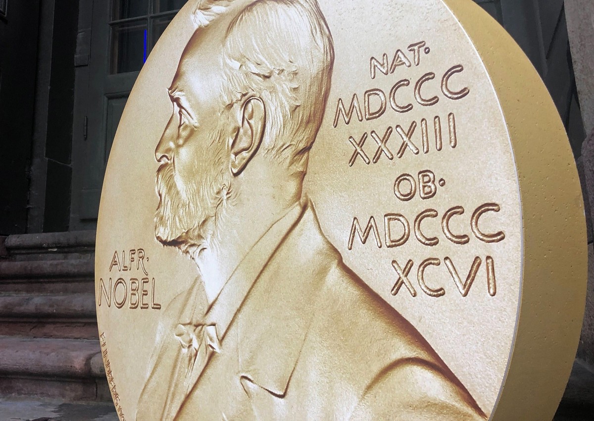 ARCHIV - 04.10.2021, Schweden, Stockholm: Ein Aufsteller in Form der prestigeträchtigen Nobelmedaille weist vor dem Nobelpreismuseum in der Altstadt Gamla Stan auf die Tage der Nobelpreis-Bekanntgaben ...