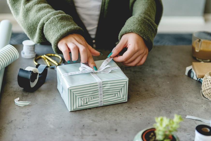 Young smiling woman packing Christmas present