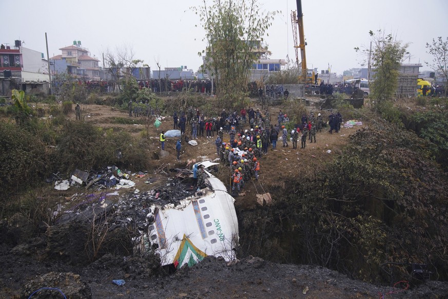 Rescuers scour the crash site in the wreckage of a passenger plane in Pokhara, Nepal, Monday, Jan.16, 2023. Nepal began a national day of mourning Monday as rescue workers resumed the search for six m ...