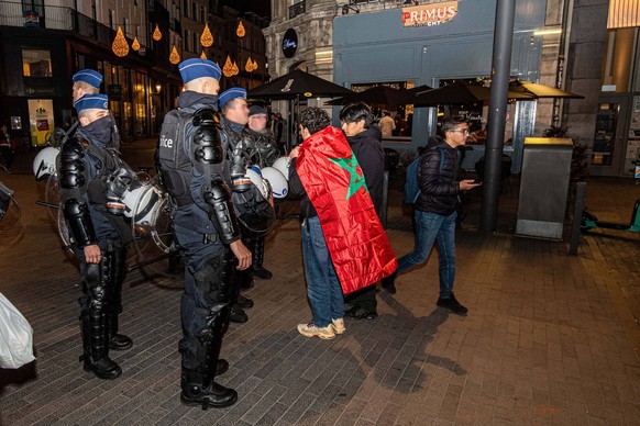 Illustration picture shows riot police talking to a young Moroccan supporter after a soccer game between Canada and Morocco , in Group F of the FIFA 2022 World Cup, in Brussels, on Thursday 01 Decembe ...
