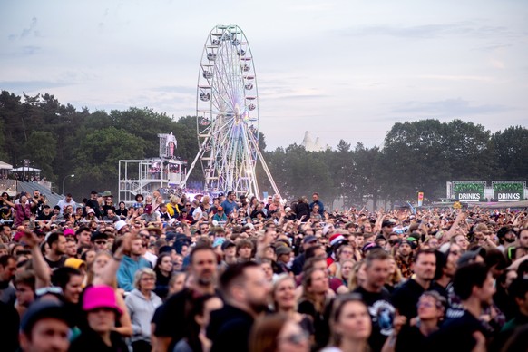 16.06.2023, Niedersachsen, Scheeßel: Zahlreiche Festivalbesucher hören sich auf dem Hurricane Festival das Konzert des deutschen Musikers Peter Fox an, während im Hintergrund ein Riesenrad auf dem Fes ...