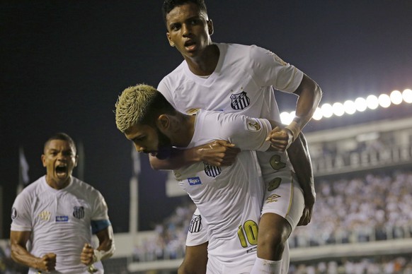 Gabriel Barbosa of Brazil's Santos, bottom, celebrates with teammate Rodrygo after Barbosa scored against Argentina's Estudiantes at a Copa Libertadores soccer match in Santos, Brazil, Tuesday, April  ...