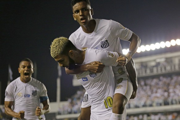 Gabriel Barbosa of Brazil's Santos, bottom, celebrates with teammate Rodrygo after Barbosa scored against Argentina's Estudiantes at a Copa Libertadores soccer match in Santos, Brazil, Tuesday, April ...