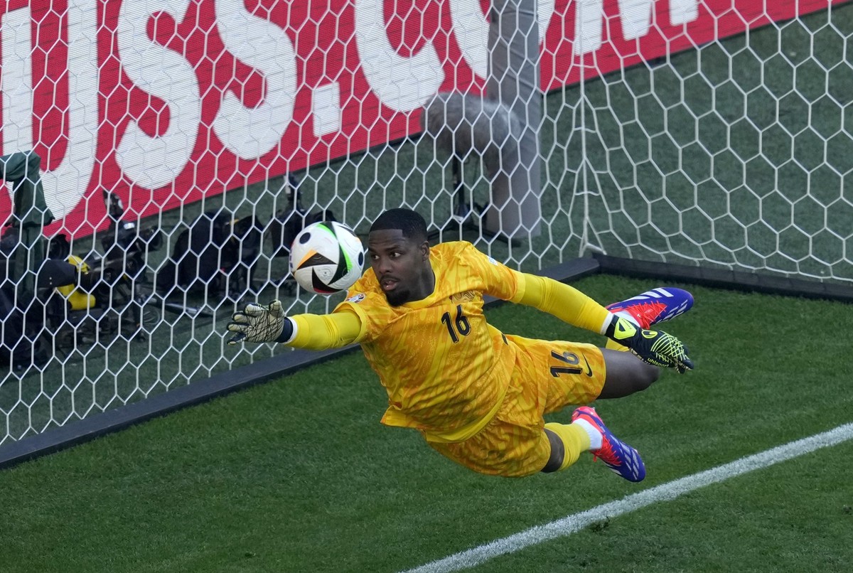 France goalkeeper Mike Maignan tries to clear the ball from the goal in a shot by Poland&#039;s Robert Lewandowski during a Group D match between the France and Poland at the Euro 2024 soccer tourname ...