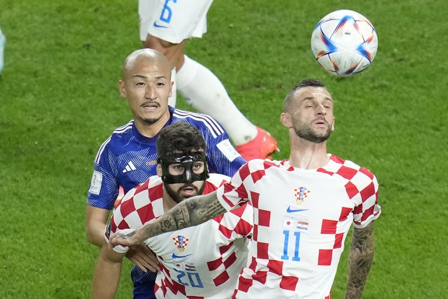 Croatia's Marcelo Brozovic, front, Croatia's Josko Gvardiol, center, and Japan's Daizen Maeda fights for the ball during the World Cup round of 16 soccer match between Japan and Croatia at the Al Jano ...