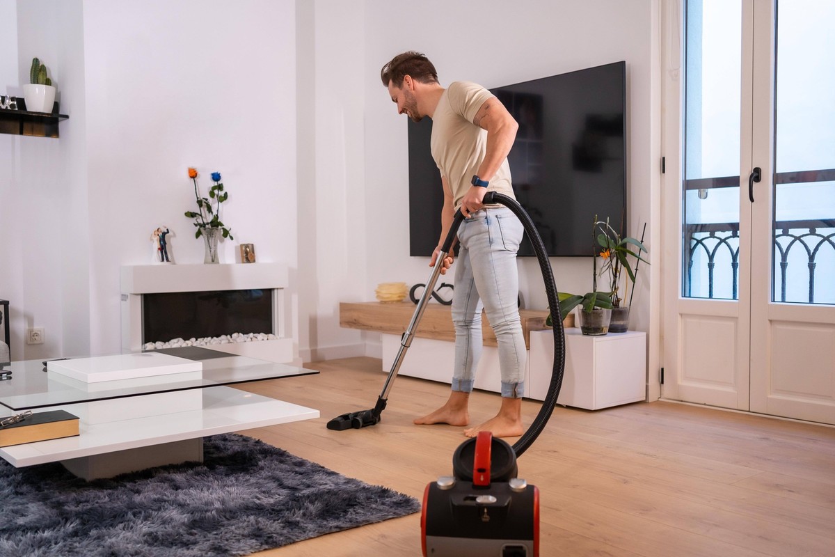 Foto mit Kopiervorlage eines Mannes beim Staubsaugen im Wohnzimmer eines Hauses *** Photo with Copy template one Man at Vacuum cleaning at Living room one House Copyright: imageBROKER/UnaixHuizi ibxuh ...