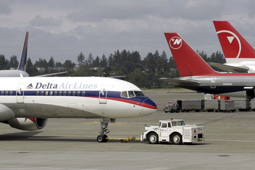 FILE - A Delta Airlines jet is pulled into position at left next to aircraft operated by Northwest Airlines at Sea-Tac International Airport Thursday, June 2, 2005 in Seattle. A former Delta Airlines  ...