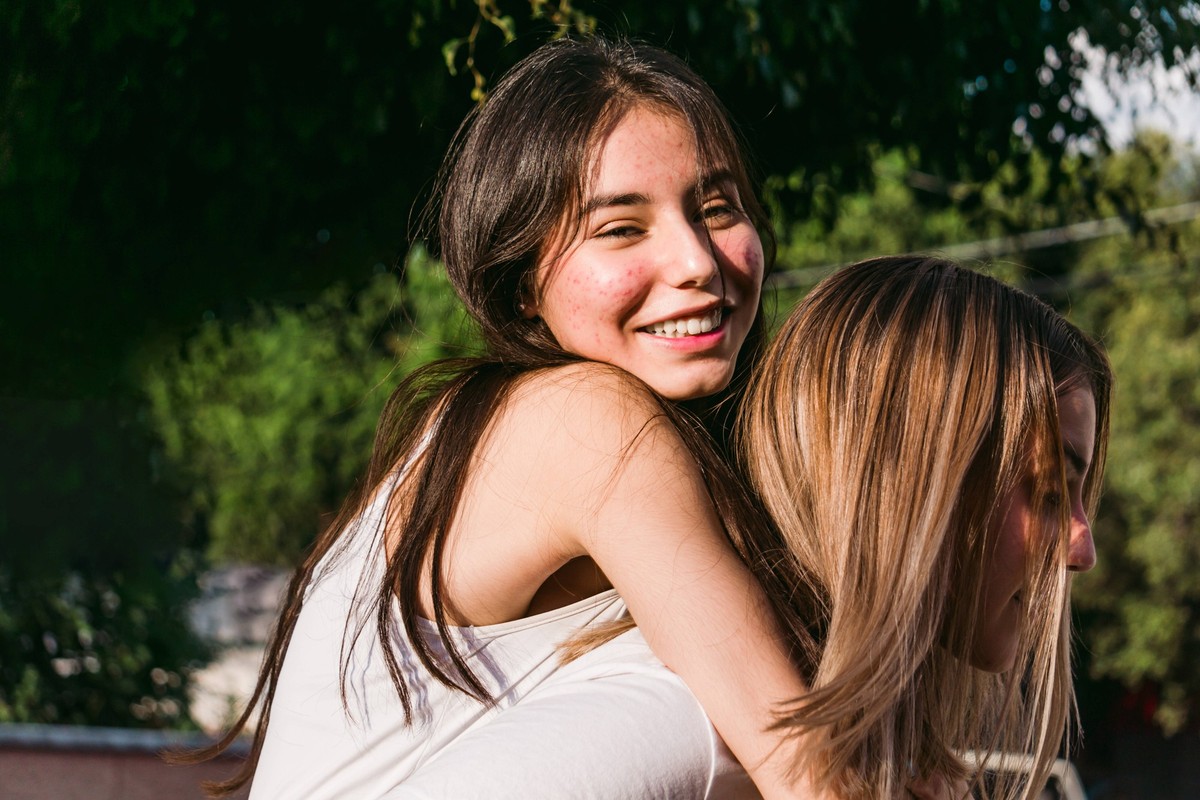 Cheerful teenager giving crop best female friend piggyback ride while looking at camera in sunny town JosedeJesusSaldana_BestFriends_10.jpg Copyright: xJosexDexJesusxSaldanax