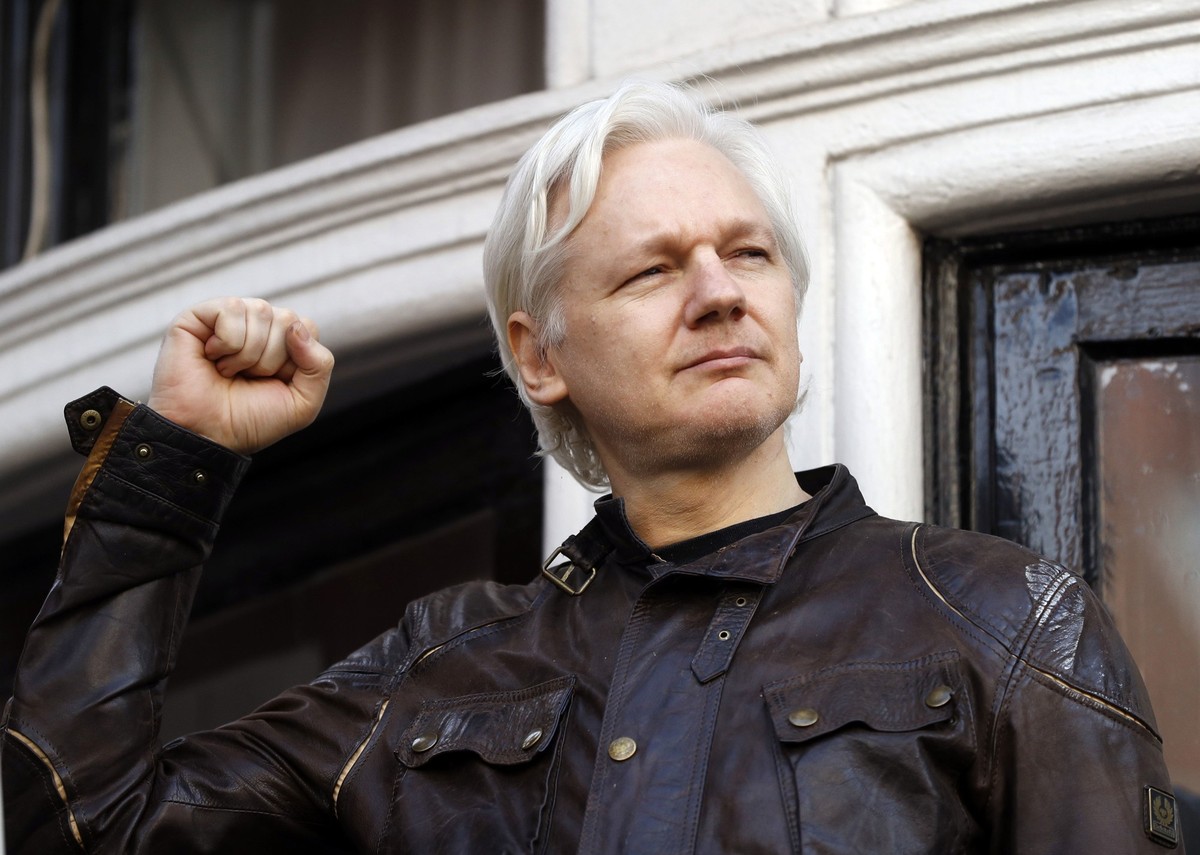 FILE - Julian Assange greets supporters outside the Ecuadorian embassy in London, May 19, 2017. (AP Photo/Frank Augstein, File)
