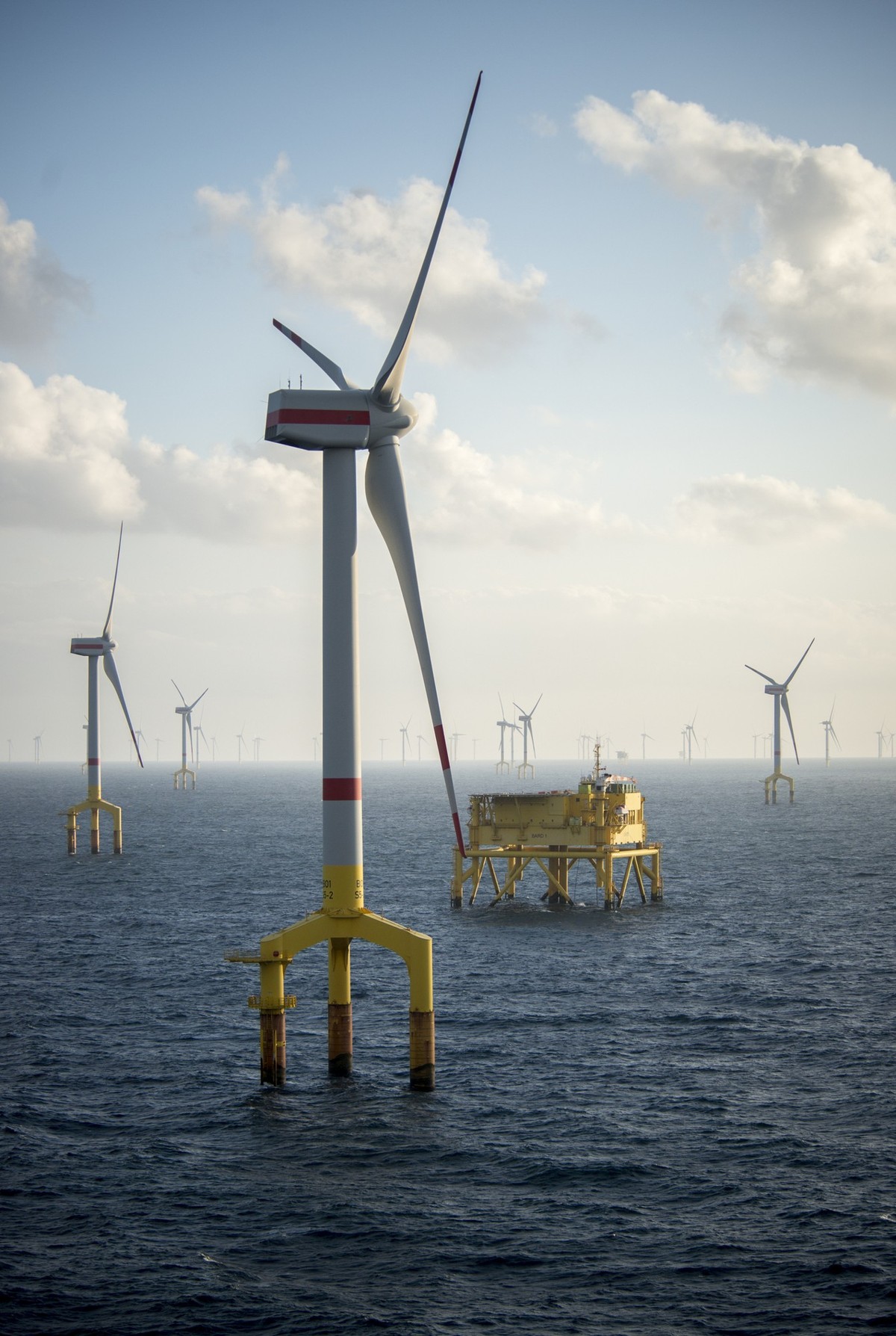 Offshore wind farm turbines at dusk in the middle of the sea
