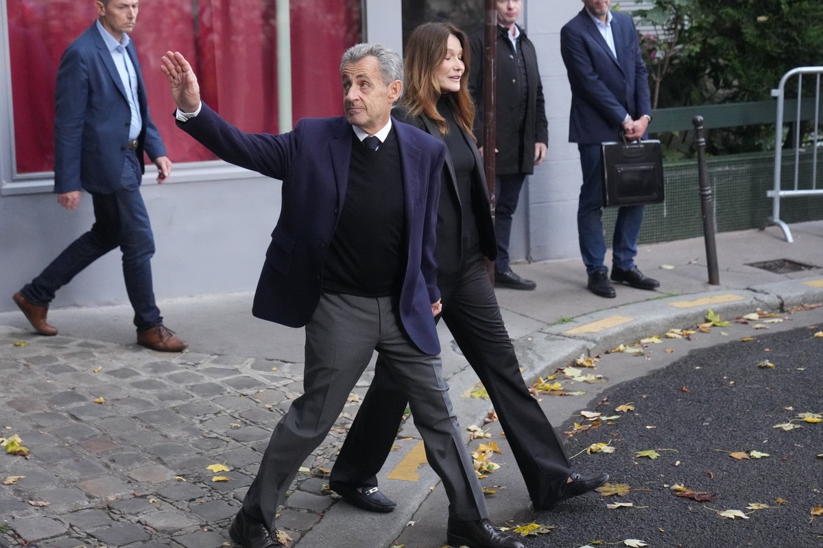 21.10.2025, Frankreich, Paris: Der ehemalige französische Präsident Nicolas Sarkozy und seine Frau Carla Bruni-Sarkozy verlassen ihr Haus in Paris, während Sarkozy ins Gefängnis geht, um seine Strafe  ...