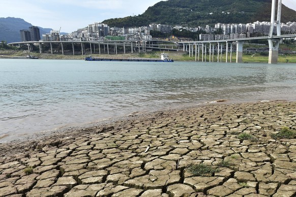A dried riverbed is exposed after the water level dropped in the Yangtze River in Yunyang county in southwest China's Chongqing Municipality, Tuesday, Aug. 16, 2022. Unusually high temperatures and a  ...