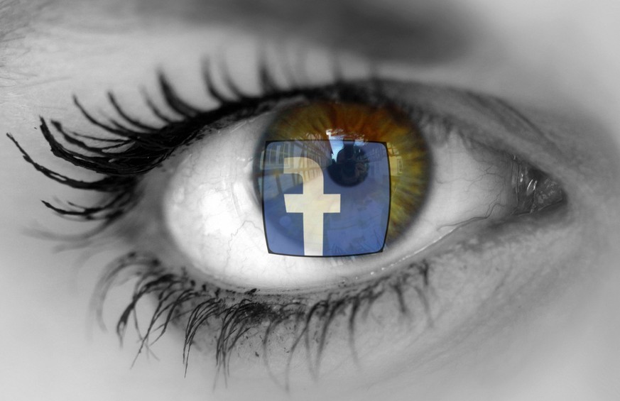 Facebook Logo spiegelt sich in den Augen einer besorgt blickenden Frau *** Facebook logo is reflected in the eyes of a worried-looking woman