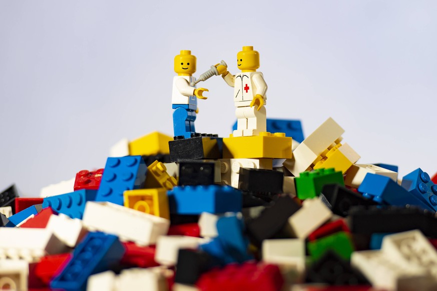 Verband der Spielwarenindustrie stellt aktuelle Zahlen vor Gesellschaft, Gesundheit, Spielwaren: Ein Arbeiter und ein Arzt stehen als Figur auf einem Berg von Legosteinen. Der Deutscher Verband der Sp ...