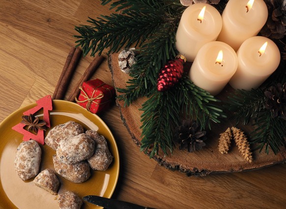 Delicious Christmas stollen on a ceramic plate in front of an Advent wreath and Christmas decorations, seasonal food