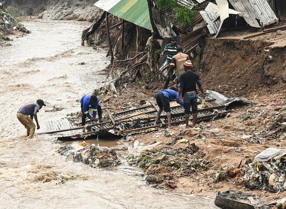 15.03.2023, Malawi, Blantyre: Männer bergen Teile ihres zerstörten Hauses nach schweren Regenfällen, die der Zyklon «Freddy» verursacht hat. Der außergewöhnlich langlebige Tropensturm «Freddy» hat zum ...