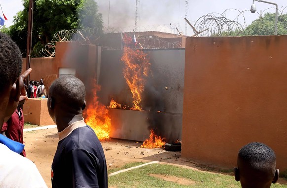 Niger, Proteste vor der Botschaft von Frankreich in Niamey Supporters Of Coup Denounce France - Niamey Supporters of Niger s junta set on fire entrance to the French embassy while forces inside the em ...