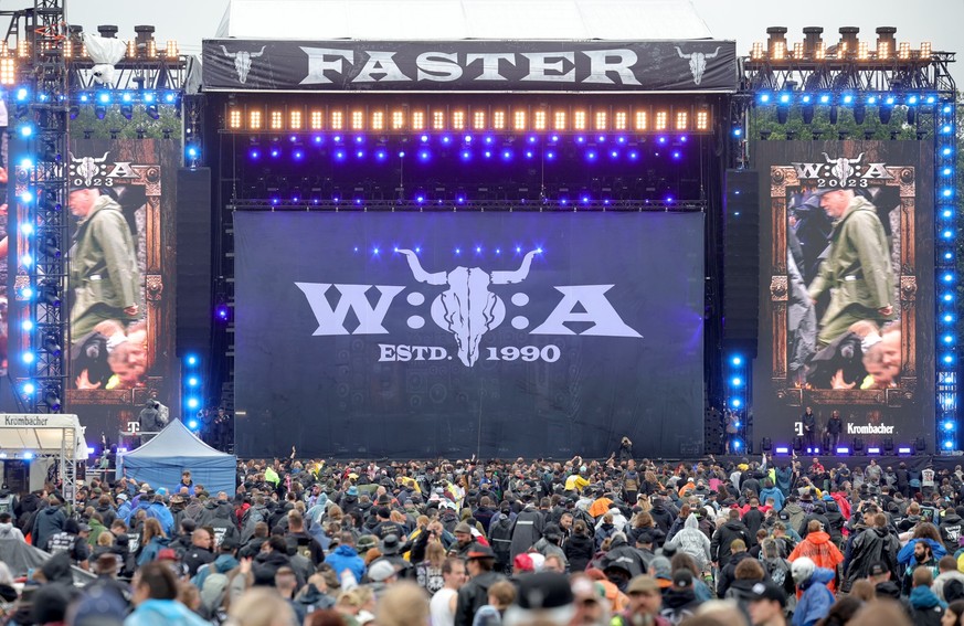 02.08.2023, Schleswig-Holstein, Wacken: Metal-Fans feiern nach der Öffnung des sogenannten &quot;Infield&quot; vor der &quot;Faster-Stage&quot;, einer der beiden Hauptbühnen, auf dem Festivalgelände.  ...