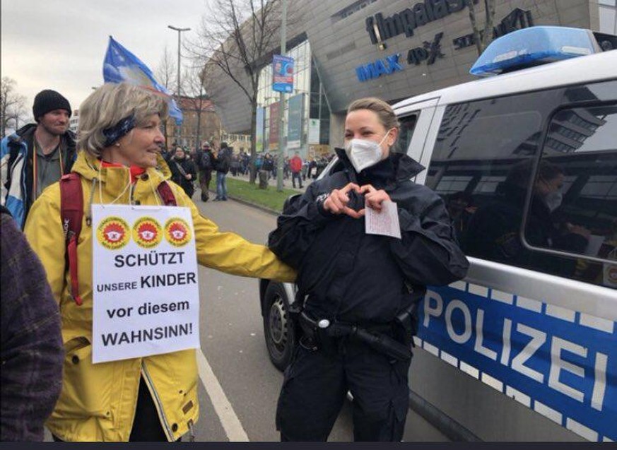 Eine Polizeibeamtin solidarisiert sich augenscheinlich mit einer Frau, die gegen die Corona-Maßnahmen demonstriert. Nicht nur dieses Bild von der Demo in Kassel sorgt für Empörung. 