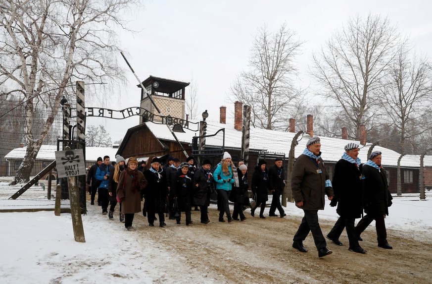 REFILE - CLARIFYING LOCATION Survivors arrive to lay wreaths at the &quot;death wall&quot; at the former Nazi German concentration and extermination camp Auschwitz, during the ceremonies marking the 7 ...
