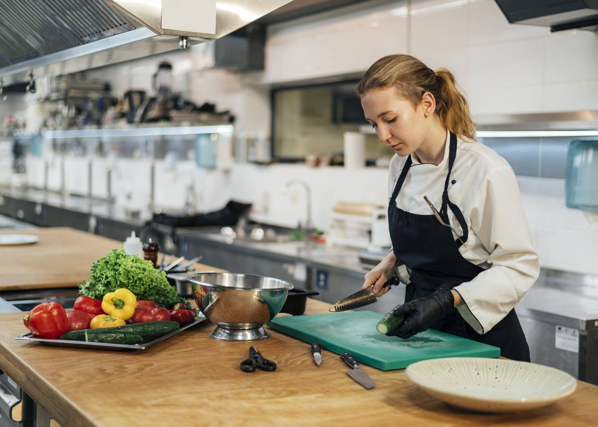 Seitenansicht weibliche Köchin Küche schneidet Gemüse *** Side view Female Cook Kitchen cuts Vegetables Copyright: imageBROKER/OleksandrxLatkun ibxole09787568.jpg Bitte beachten Sie die gesetzlichen B ...