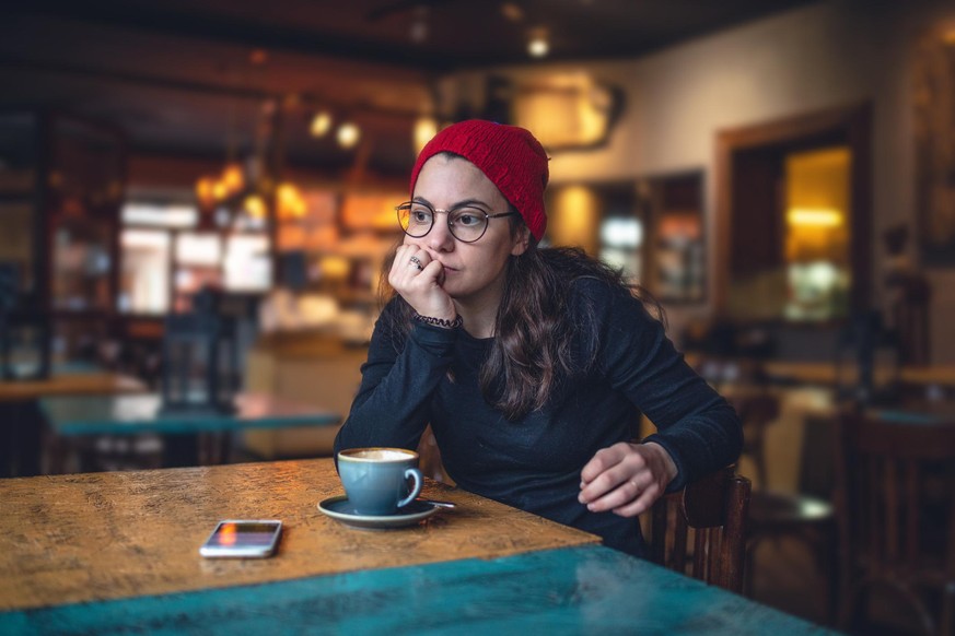 Eine Frau sitzt allein im Café.