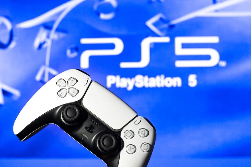 SPAIN - 2021/11/08: In this photo illustration, a PlayStation 5 controller seen with a PlayStation 5 logo in the background. (Photo Illustration by Thiago Prudencio/SOPA Images/LightRocket via Getty I ...