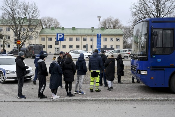 Police officers talk to family members of pupils at the Viertola comprehensive school in Vantaa, Finland, on April 2, 2024. Three minors were injured in a shooting at the school on Tuesday morning. A  ...