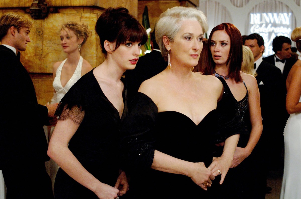 Andy Anne Hathaway, left whispers some important information to her boss, fashion magazine editor Miranda Priestly Meryl Streep, as Mirandas first assistant, Emily Emily Blunt looks on. PHOTOGRAPHS TO ...