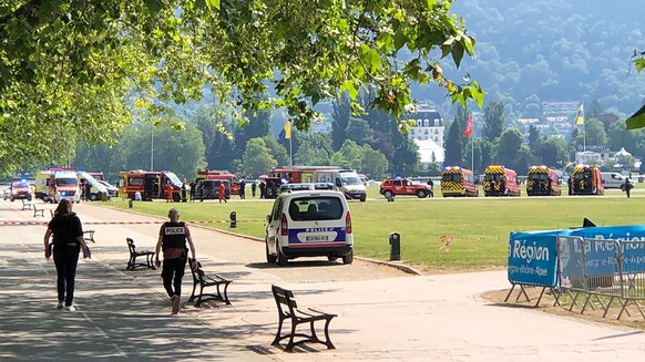 08.06.2023, Frankreich, Annecy: Polizisten und Rettungskräfte gehen nach einem Messerangriff in einem Park zum Tatort. Ein Angreifer hat in einem Park in der ostfranzösischen Stadt Annecy mehrere Klei ...
