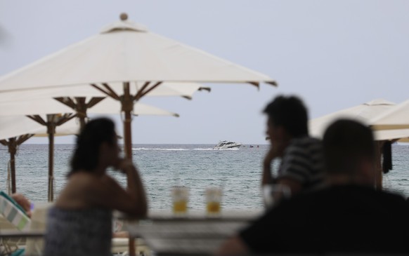 18.06.2023, Spanien, Arenal: Menschen genießen die warmen Temperaturen in einer Strandbar in dem Badeort S`Arenal auf der Baleareninsel Mallorca. Foto: Clara Margais/dpa +++ dpa-Bildfunk +++