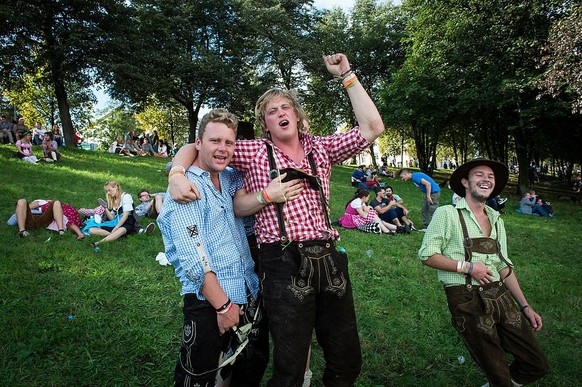 MUNICH, GERMANY - SEPTEMBER 20: Drunken or tired visitors in traditional bavarian clothes take a rest during the opening day of the 2014 Oktoberfest on September 20, 2014 in Munich, Germany. Oktoberfe ...