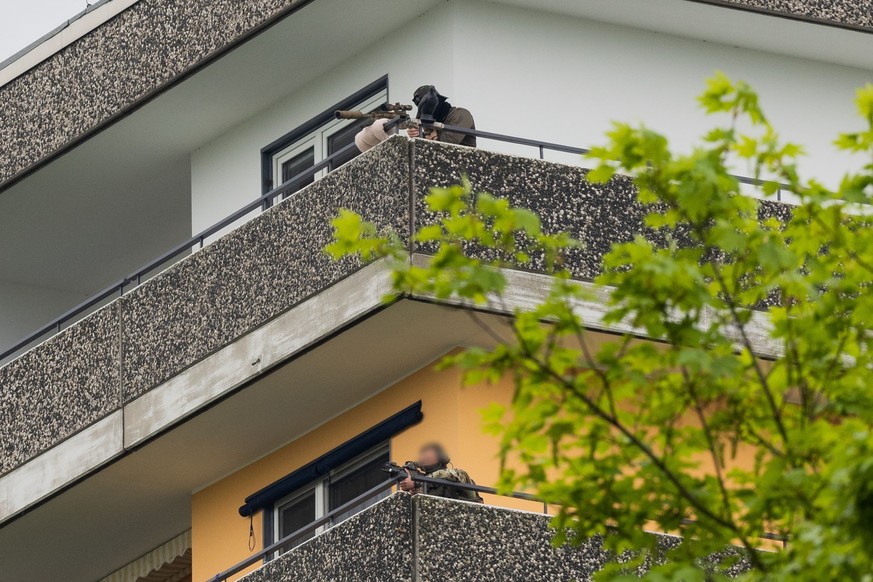 11.05.2023, Nordrhein-Westfalen, Ratingen: Ein Scharfschützen (oben) und ein weiterer Beamter der Polizei sind auf einem Hochhaus mit ihren Waffen in Stellung gegangen. Bei einer Explosion in einem Ho ...