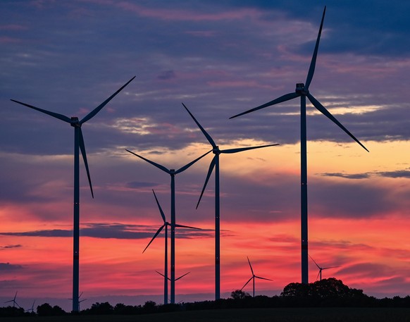 Zur goldenen Stunde, etwa eine Stunde vor Sonnenaufgang, drehen sich die Rotorblätter von Windenergieanlagen im Wind. Das Land Brandenburg nimmt Platz 2 in der Rangliste der Bundesländer mit der größt ...