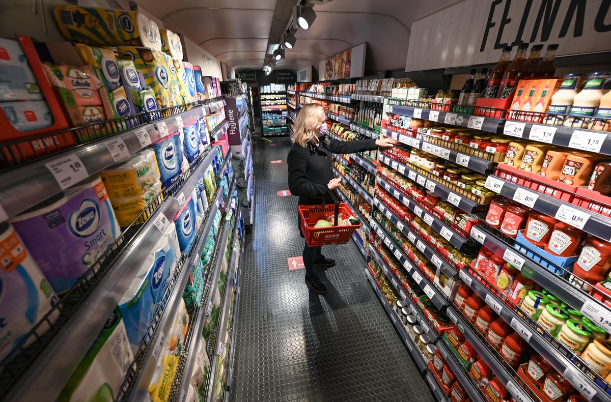 ILLUSTRATION - Eine Frau steht bei der Vorstellung des temporären Projekts "Fairer Supermarkt im Zug" im Frankfurter Hauptbahnhof mit einem Einkaufskorb vor einem Lebensmittelregal. Der fair ...