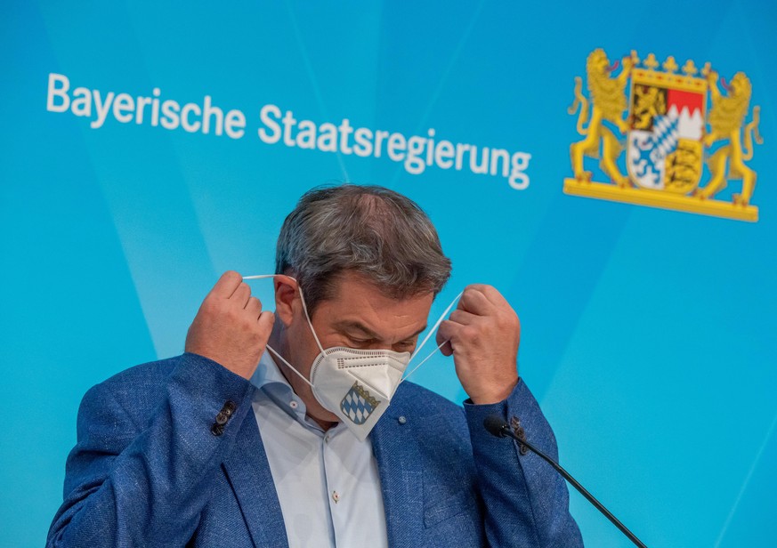 04.06.2021, Bayern, München: Markus Söder (CSU), Ministerpräsident von Bayern, nimmt auf einer Pressekonferenz nach der Kabinettssitzung der bayerischen Staatsregierung seine FFP-2-Maske ab. Foto: Pet ...