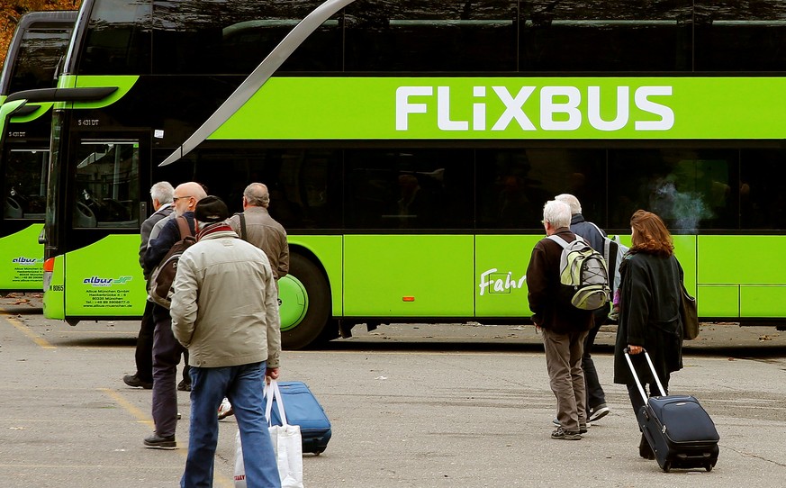 FILE PHOTO: Passengers walk in front of a FlixBus intercity bus at the Carparkplatz Sihlquai bus station in Zurich, Switzerland October 27, 2016. REUTERS/Arnd Wiegmann/File Photo