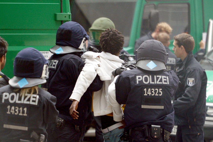 Ein Mann wird am 02.10.2014 vor der DGB-Zentrale in der Berliner City-West bei der Räumung des besetzten Gebäudes von Polizeibeamten abgeführt. Die Polizei hat die seit einer Woche von Flüchtlingen be ...