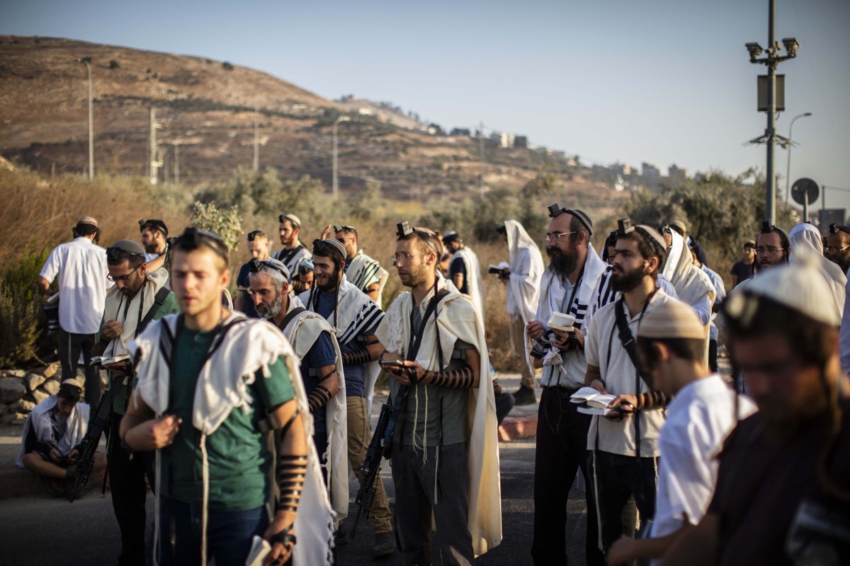 04.10.2022, Palästinensische Autonomiegebiete, Nablus: Israelische rechtsgerichtete Siedler beten und blockieren den Haupteingang der palästinensischen Stadt Nablus im nördlichen Westjordanland. Foto: ...