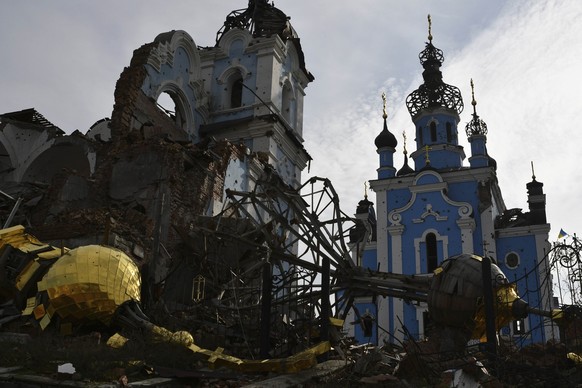22.10.2022, Ukraine, Bohorodychne: Zerst�rte Kuppeln liegen neben einer besch�digten Kirche in einem zur�ckeroberten Dorf in der Ostukraine. Foto: Andriy Andriyenko/AP/dpa +++ dpa-Bildfunk +++
