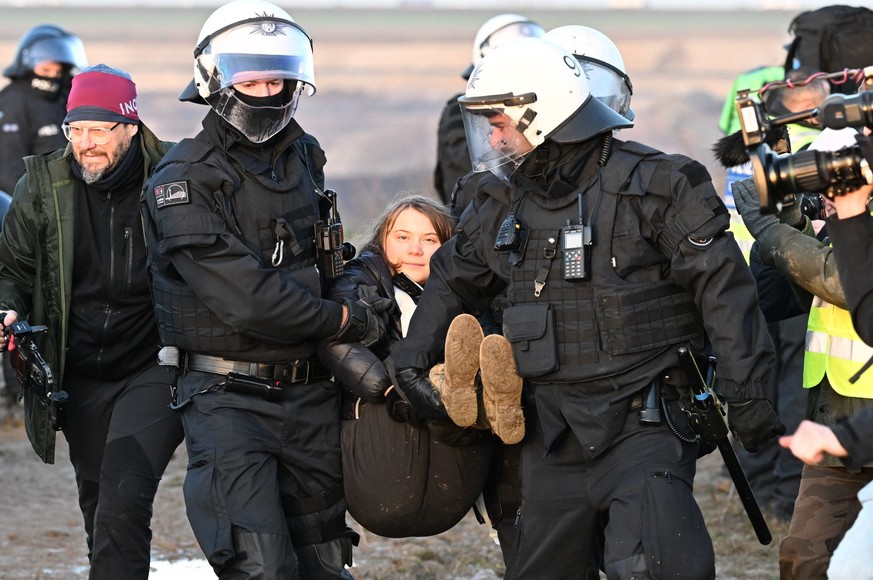 17.01.2023, Nordrhein-Westfalen, Erkelenz: Polizisten tragen die schwedische Klimaaktivistin Greta Thunberg (M) aus einer Gruppe von Demonstranten und Aktivisten heraus und vom Rand des Braunkohlentag ...