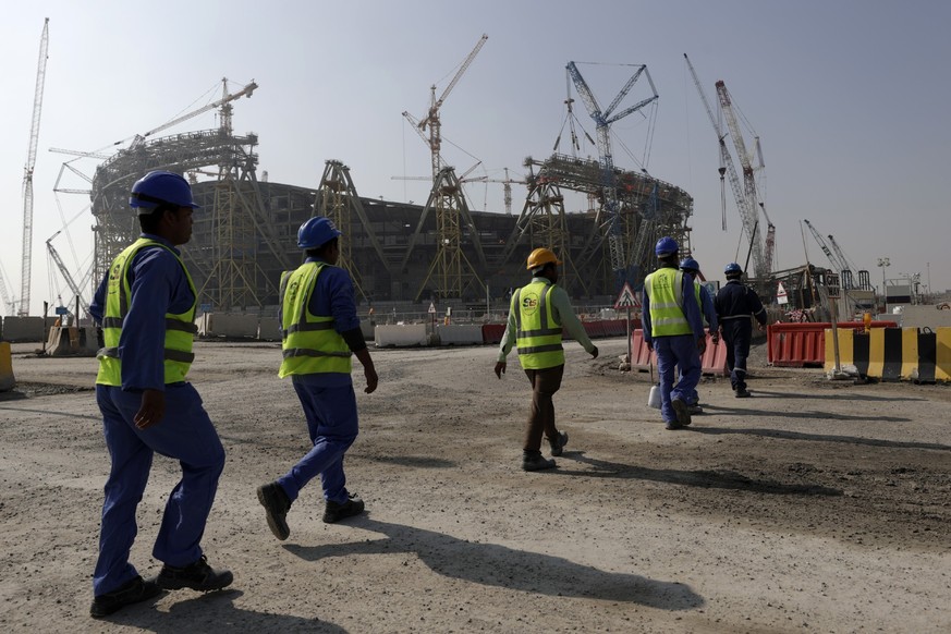 FILE - Workers walk to the Lusail Stadium, one of the 2022 World Cup stadiums, in Lusail, Qatar, Friday, Dec. 20, 2019. Paris has decided not to display the matches of the World Cup in Qatar on giant  ...