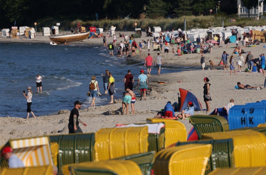 BINZ, GERMANY - AUGUST 04: People relax at a beach among traditional wicker beach chairs on the Baltic Sea coast on Rügen Island on August 04, 2021 in Binz, Germany. Holiday destinations along Germany ...