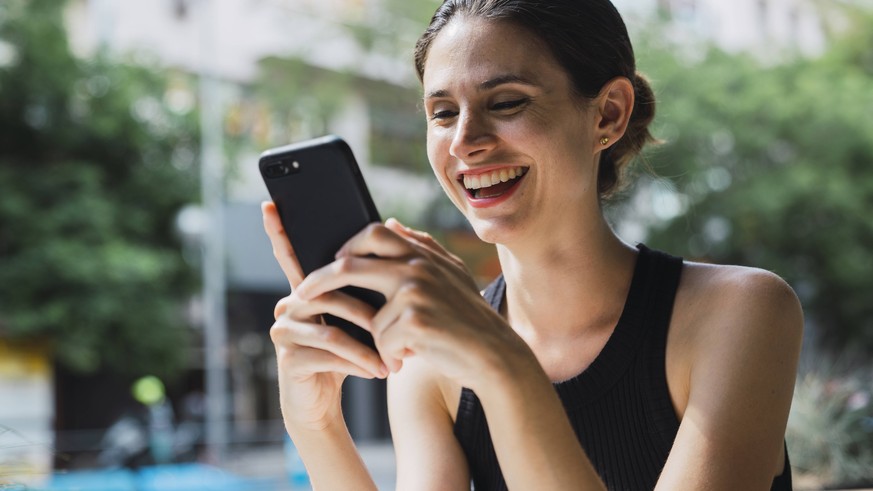 Young woman sitting in cofee shop, using smartphone model released Symbolfoto PUBLICATIONxINxGERxSUIxAUTxHUNxONLY KKAF01267