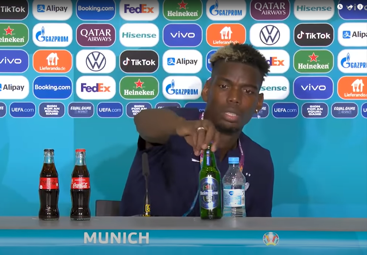 Pogba entfernt die Bierflasche vom Tisch.