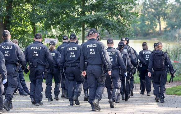 15.09.2023, Mecklenburg-Vorpommern, Pragsdorf: Polizisten durchk�mmen den Bereich rund um den Tatort am See, wo am Abend des 14.09.2023 der schwer verletzte Sechsj�hrige gefunden wurde, der sp�ter an  ...