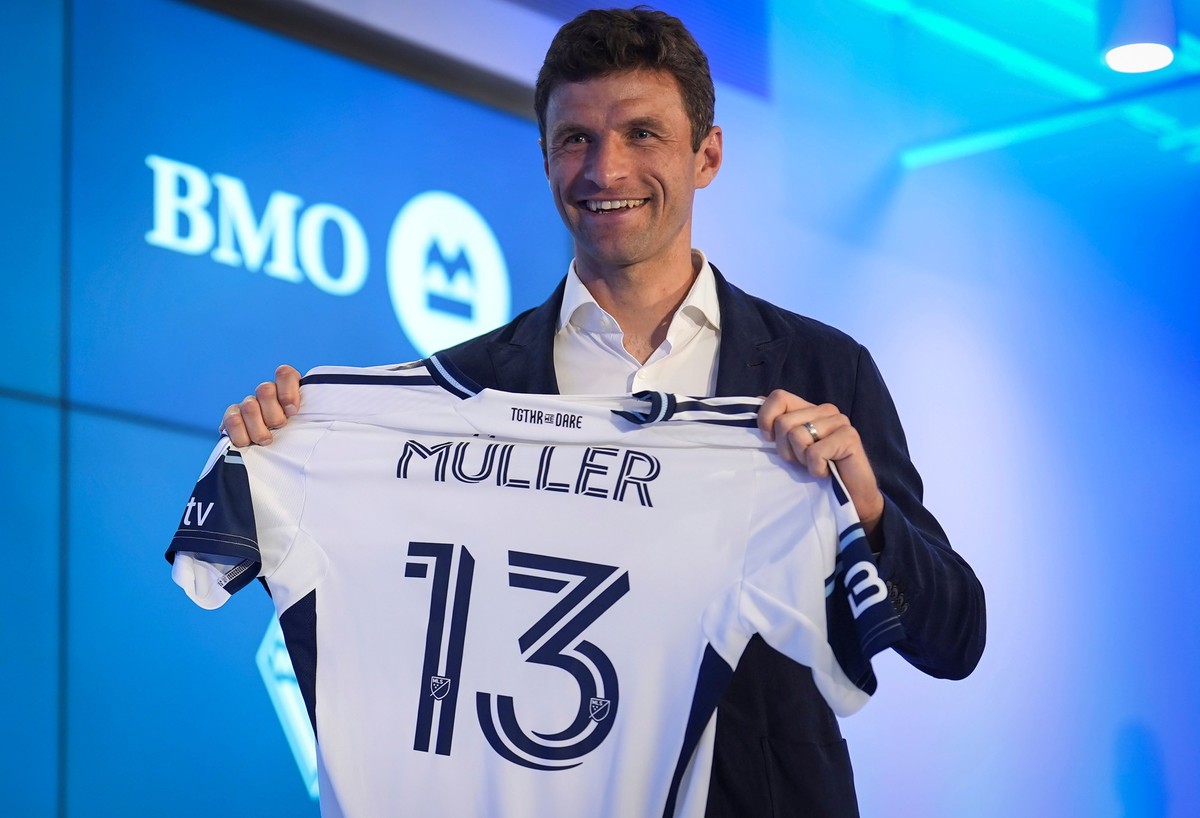 New Vancouver Whitecaps player Thomas Muller, of Germany, poses with his jersey during an MLS soccer news conference, Thursday, Aug. 14, 2025, in Vancouver, British Columbia. (Darryl Dyck/The Canadian ...