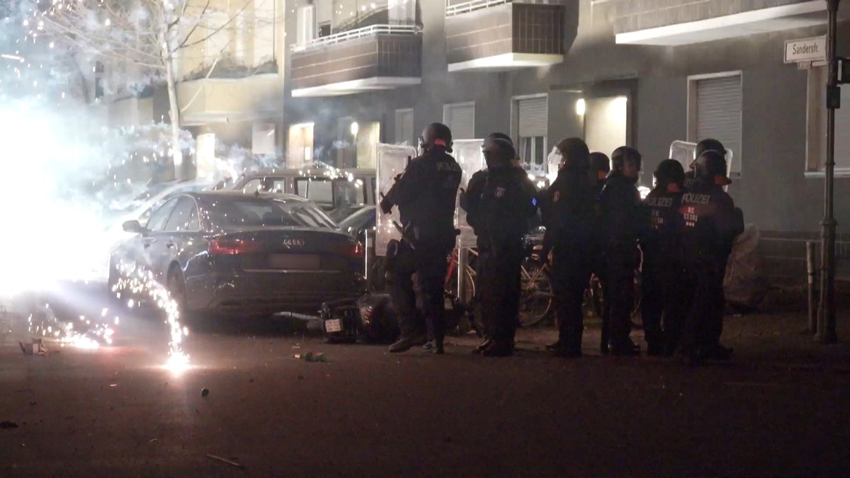 ARCHIV - 31.12.2022, Berlin: Polizisten stehen in der Silvesternacht 2022 hinter explodierendem Feuerwerk. (zu: &quot;Mehr Polizei und Böllerverbote - Politik will Silvester ohne Krawalle&quot;) Foto: ...