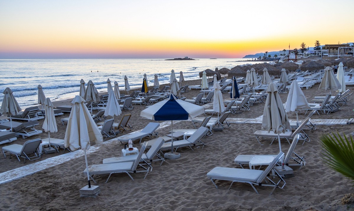 Sommer auf Kreta Sonnenschirme und Strandliegen stehen am Strand des Mittelmeeres in Malia auf der Insel Kreta. Malia Kreta Griechenland *** Summer in Crete beach umbrellas and beach chairs stand on t ...