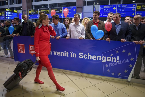 dpatopbilder - 31.03.2024, Rumänien, Otopeni: Eine Flugbegleiterin geht an einem Schild mit der Aufschrift &quot;Willkommen in Schengen&quot; vorbei, als sie auf dem internationalen Flughafen Henri Co ...
